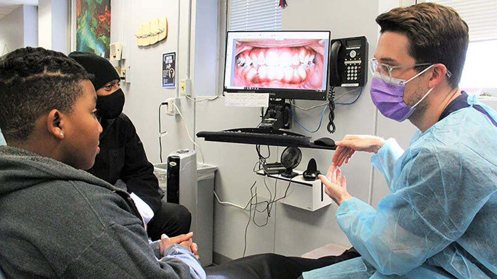 VCU School of Dentistry student and professor performing dental care services to a community member